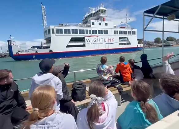 Picture of school children on water waving to Wightlink ferry